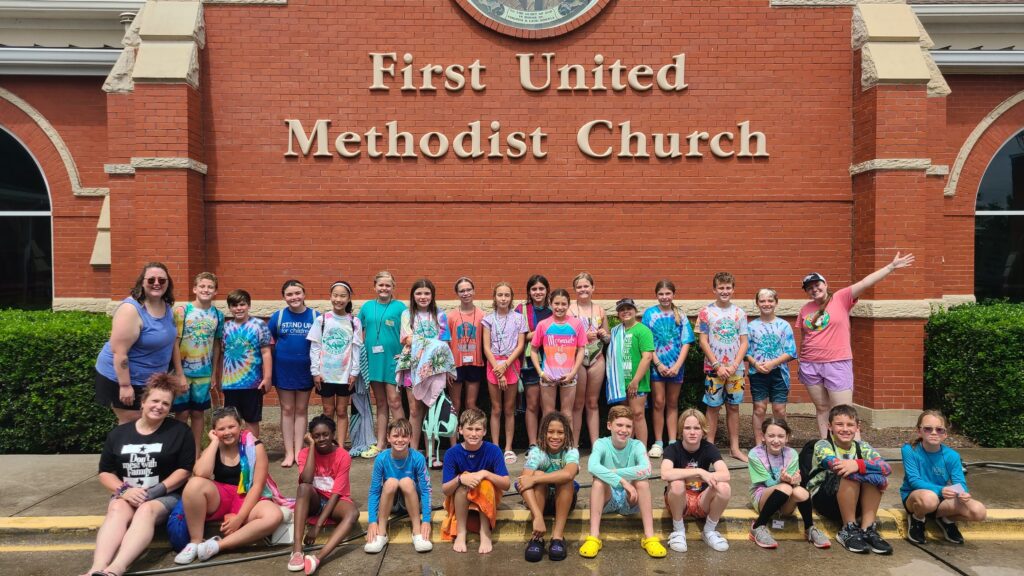 A group of youth smiling outside the church